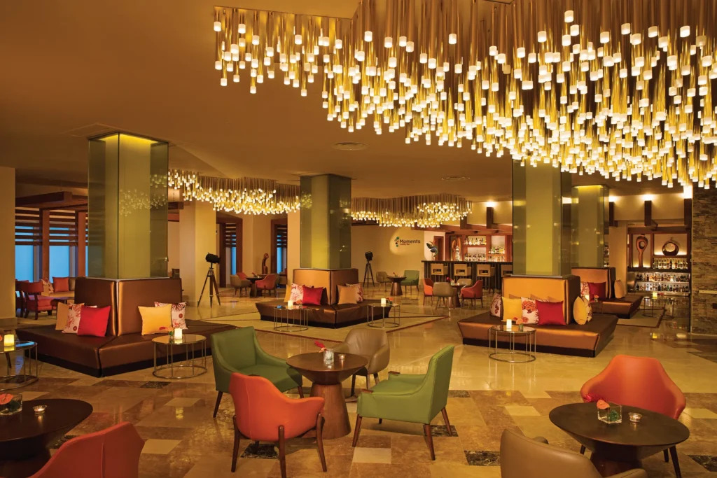 Moments Lobby Bar at Dreams Onyx Resort & Spa featuring stylish lounge seating, handcrafted cocktails, and a welcoming open-air lobby atmosphere.