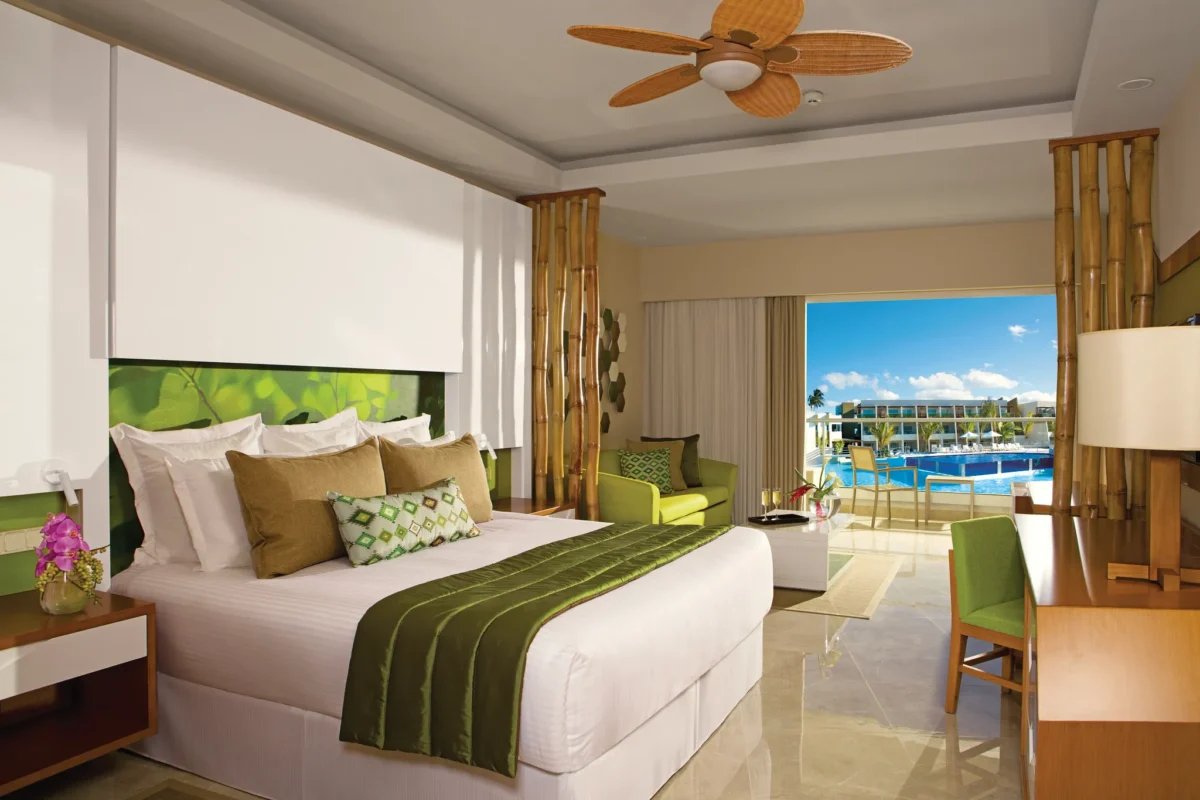 Preferred Club Junior Suite Pool View with king bed and balcony overlooking the pool at Dreams Onyx Resort & Spa.