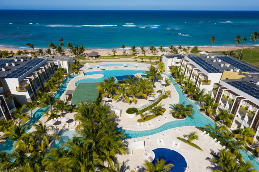 Aerial view of large resort pool surrounded by palm trees at Dreams Onyx Resort & Spa.