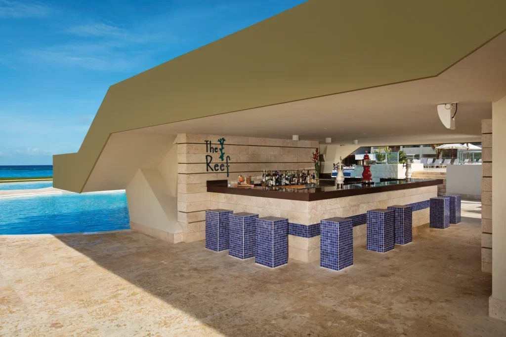 The Reef Pool Bar at Dreams Onyx Resort & Spa featuring a lively main pool setting, refreshing cocktails, and a relaxed tropical atmosphere.