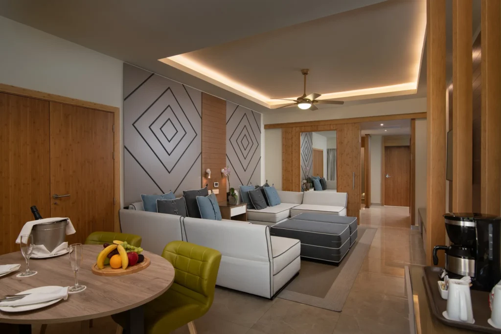 Two Bedroom Family Suite living area with dining table and sofa seating at Dreams Onyx Resort & Spa.