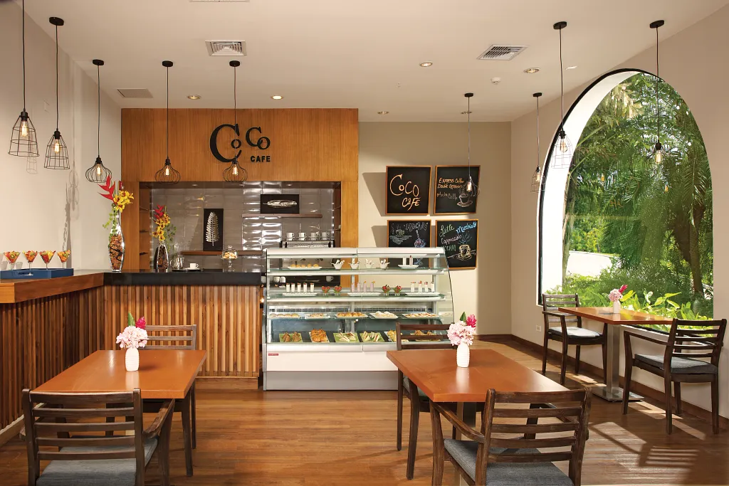 Coco Café at Dreams Playa Bonita Panama featuring a bright café interior, premium coffee service, and relaxed seating with garden views.
