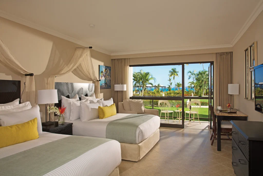 Deluxe Partial Ocean View room with two double beds and balcony at Dreams Playa Bonita Panama overlooking tropical gardens.