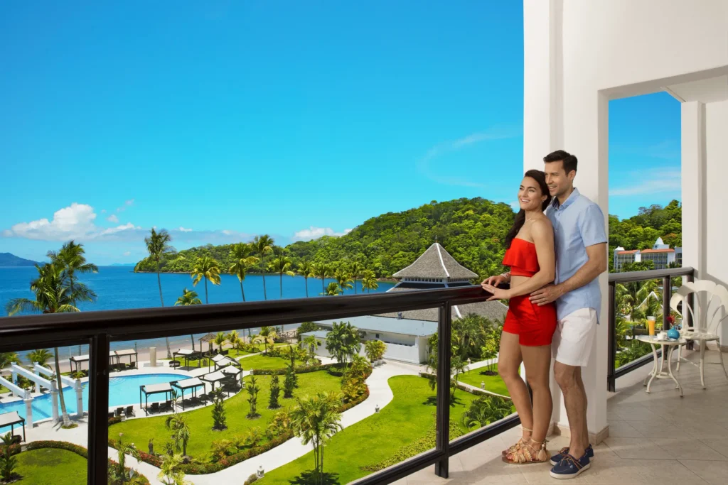 Couple relaxing on the Preferred Club Junior Suite Ocean View balcony at Dreams Playa Bonita Panama.