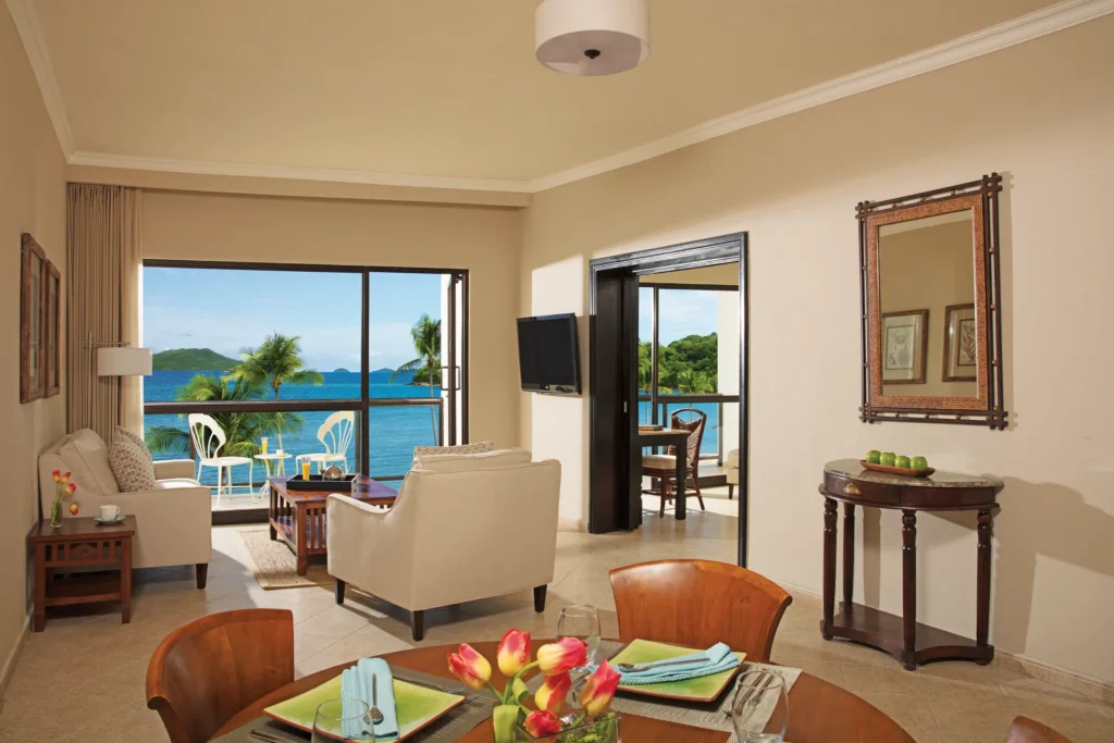 Preferred Club Junior Suite Ocean View living area with seating and balcony at Dreams Playa Bonita Panama.