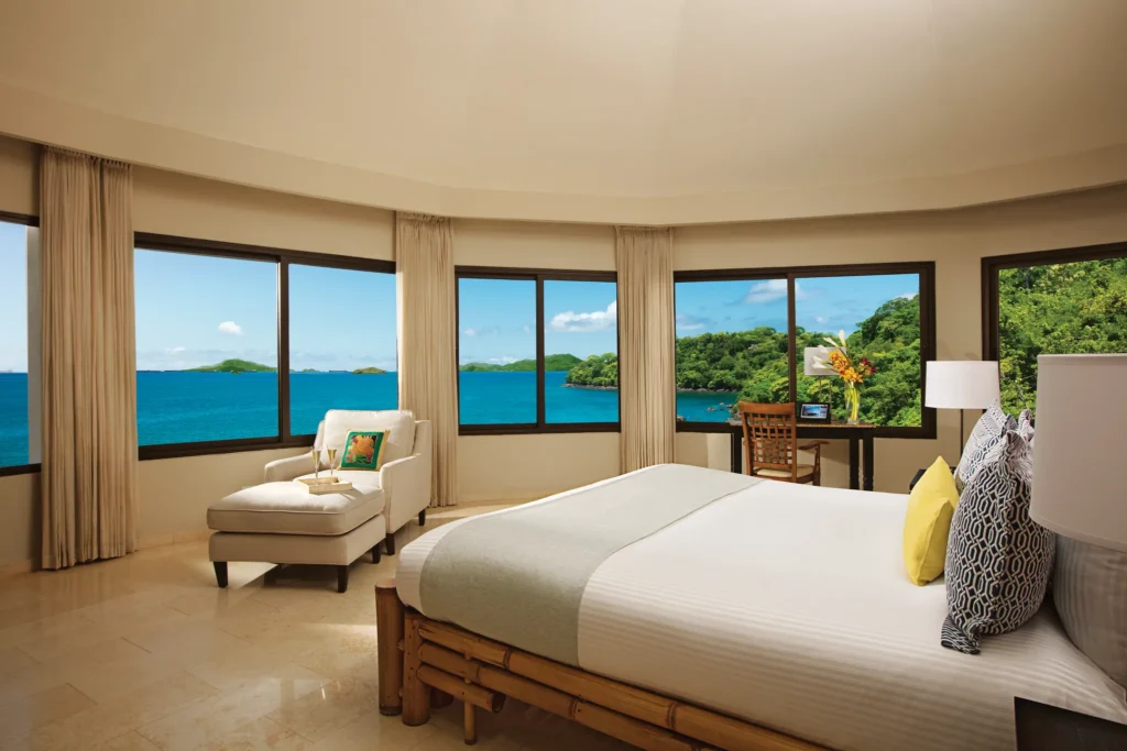Preferred Club Master Suite Ocean View bedroom with king bed and panoramic windows at Dreams Playa Bonita Panama.