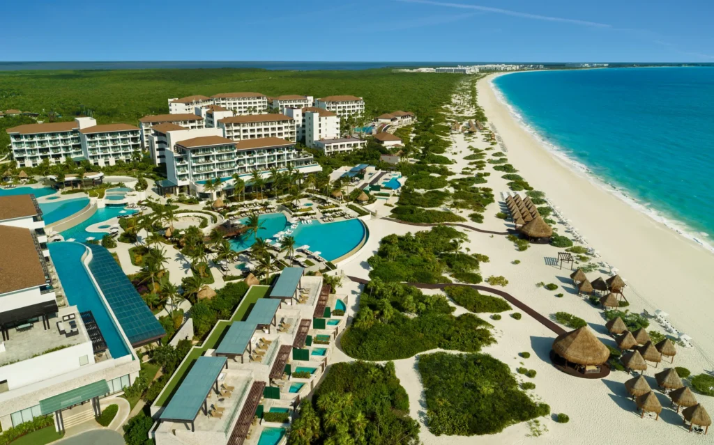 Aerial view of Dreams Playa Mujeres Resort with pools, beachfront, and turquoise Caribbean waters.