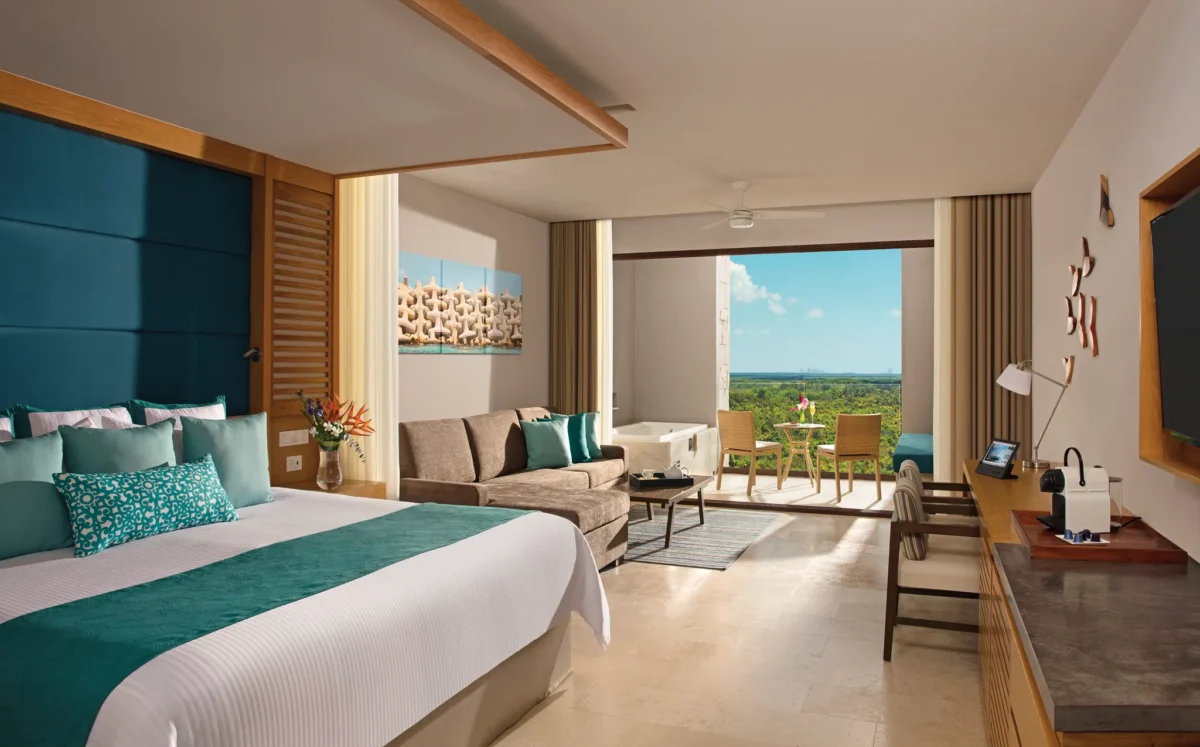 Family Junior Suite Garden View with terrace and seating area at Dreams Playa Mujeres Golf & Spa Resort.