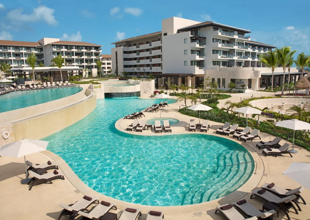 Lagoon-style grotto pool with lounge chairs at Dreams Playa Mujeres Resort in Cancun.