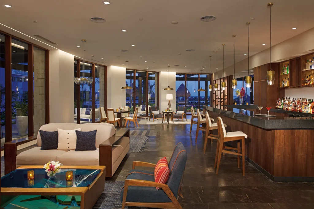 Elegant Preferred Club lounge with bar seating and ocean views at Dreams Playa Mujeres Resort.