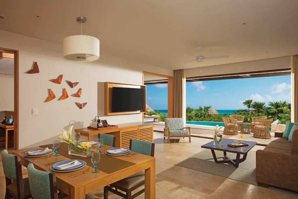 Living and dining area with oceanfront terrace and private pool view.