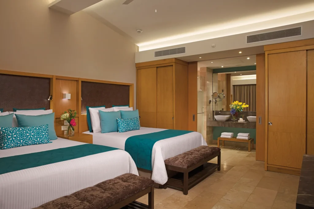 Bedroom with two queen beds and modern decor in villa suite.
