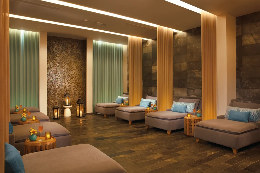 Relaxation lounge with cushioned daybeds and ambient lighting at Dreams Playa Mujeres Resort spa.