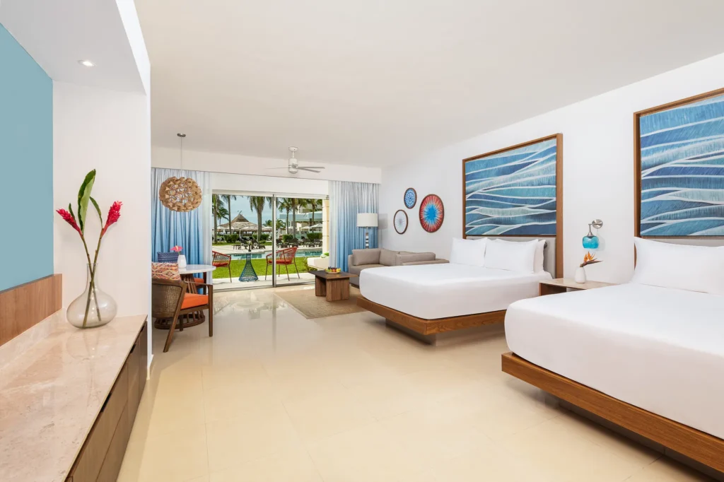 Junior Suite Pool View Double room with two beds and balcony access at Dreams Puerto Morelos Resort.