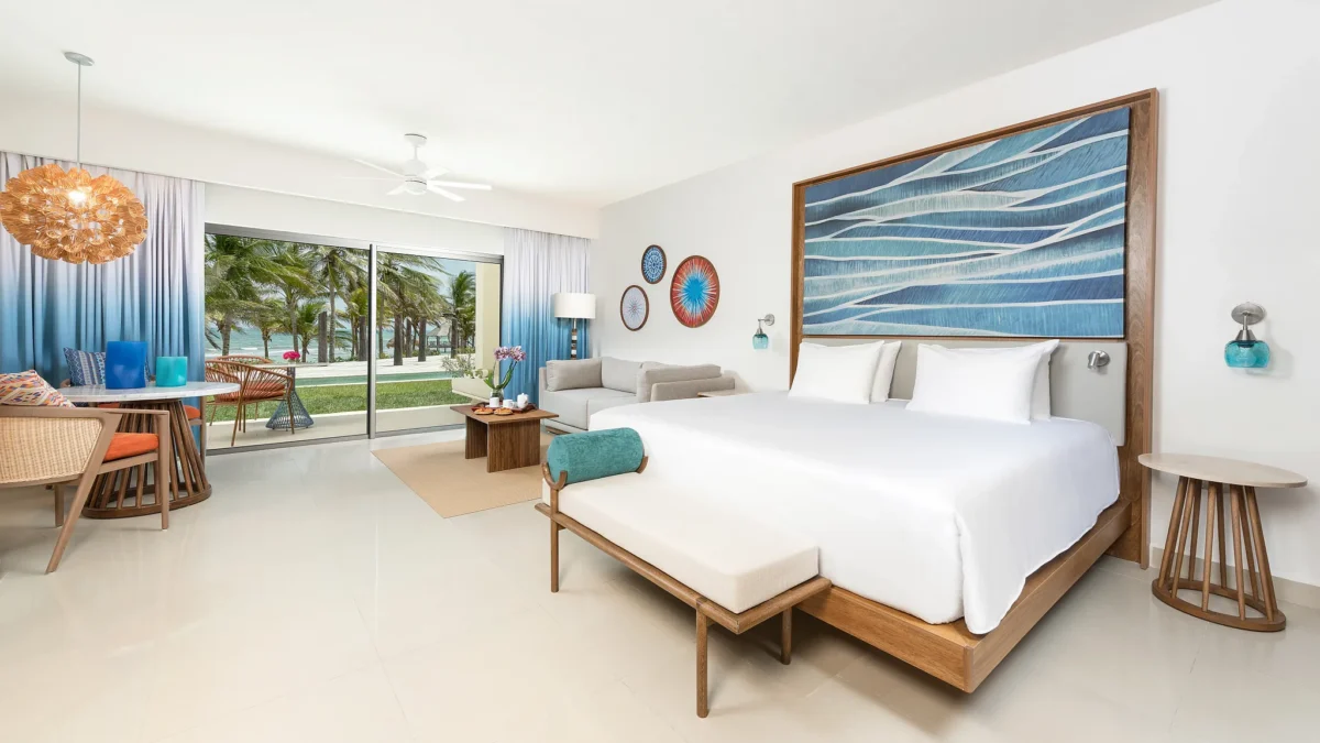Junior Suite Pool View King bedroom with balcony access and modern decor at Dreams Puerto Morelos Resort.