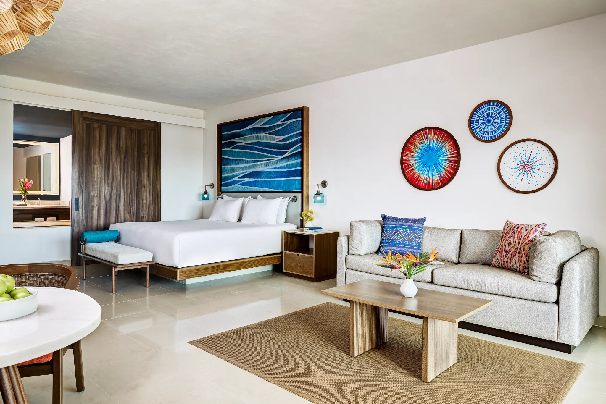Junior Suite Tropical View King bedroom with sofa and modern decor at Dreams Puerto Morelos Resort.