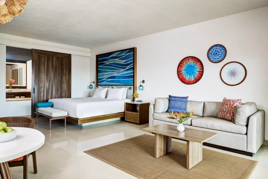 Junior Suite Waterpark View King bedroom with sofa and modern decor at Dreams Puerto Morelos Resort.