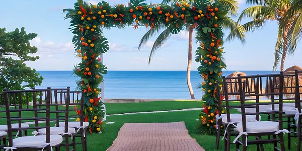 Mango Garden wedding ceremony setup with tropical arch at Dreams Puerto Morelos Resort & Spa