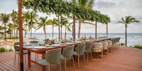 Papaya Deck oceanfront reception setup with long table at Dreams Puerto Morelos Resort & Spa
