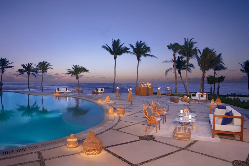 Pool area wedding reception setup with tables and tropical views at Dreams Puerto Morelos Resort & Spa