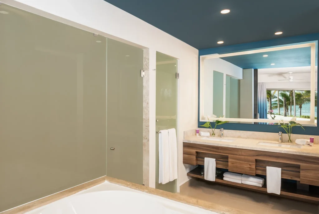 Preferred Club Junior Suite Ocean Front King bathroom with double sinks and glass shower at Dreams Puerto Morelos.