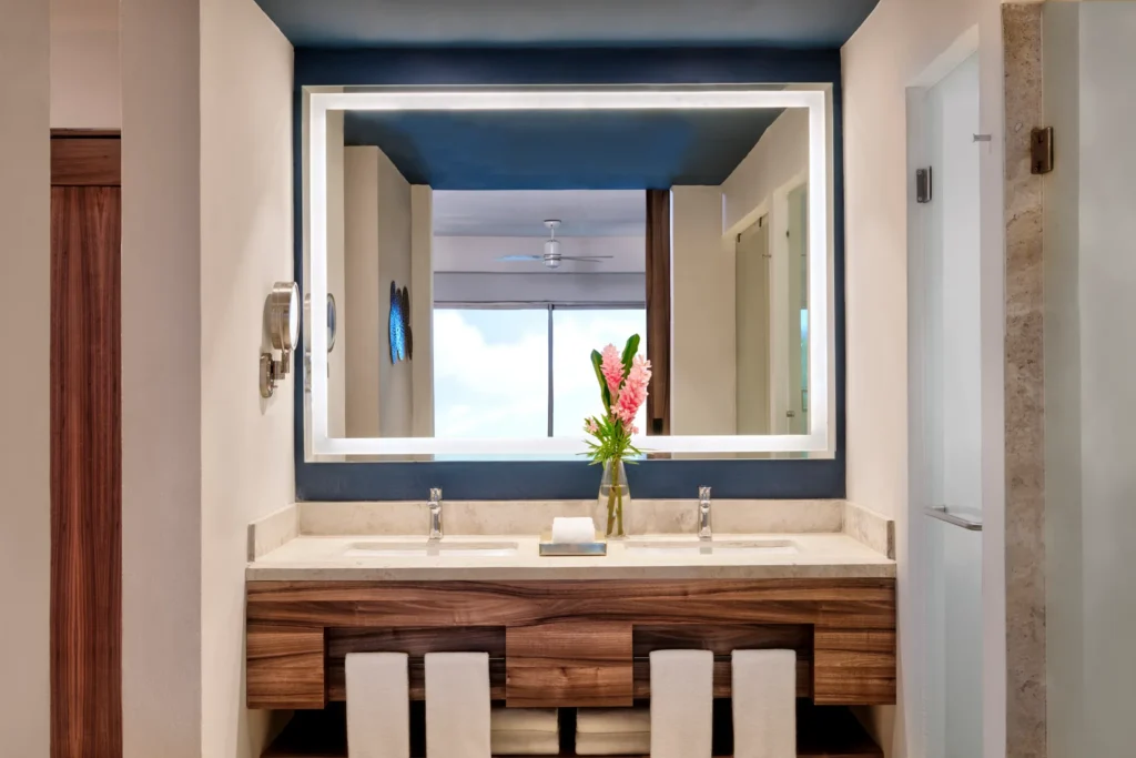 Preferred Club Junior Suite Ocean View King bathroom with double sinks and illuminated mirror at Dreams Puerto Morelos.