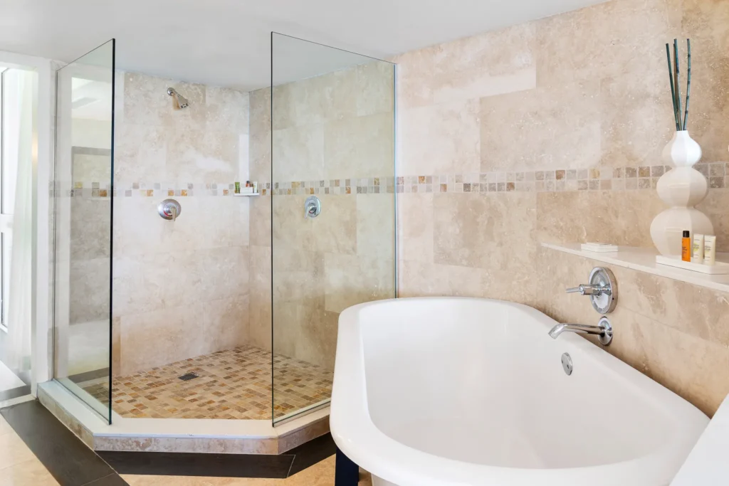 Oceanfront Prime Minister Suite luxury bathroom with soaking tub and walk-in shower at Dreams Rose Hall Resort & Spa.