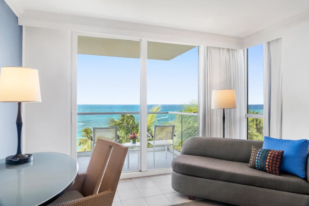 Oceanfront Royal Suite seating area with private balcony and Caribbean Sea views at Dreams Rose Hall Resort & Spa.