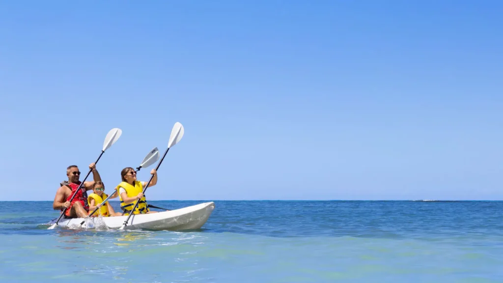 Family kayaking together on the Caribbean Sea at Dreams Rose Hall Resort & Spa in Montego Bay, Jamaica.