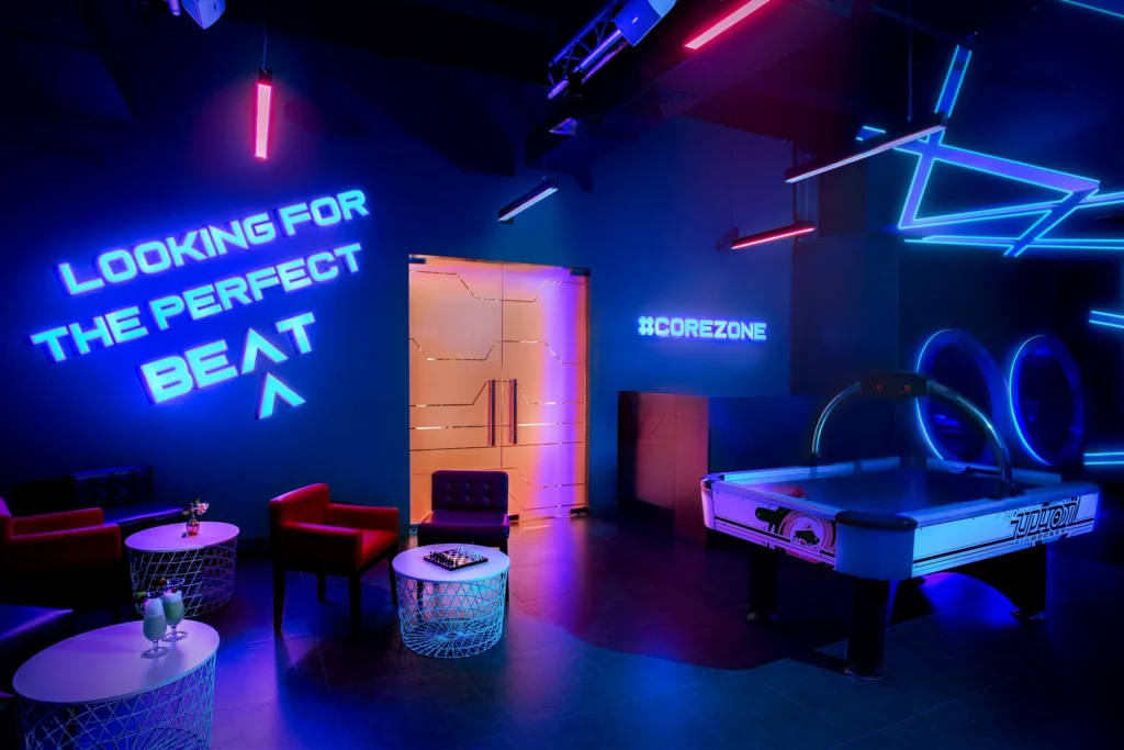 Neon-lit game room with air hockey and lounge seating at Dreams Royal Beach Punta Cana Core Zone.