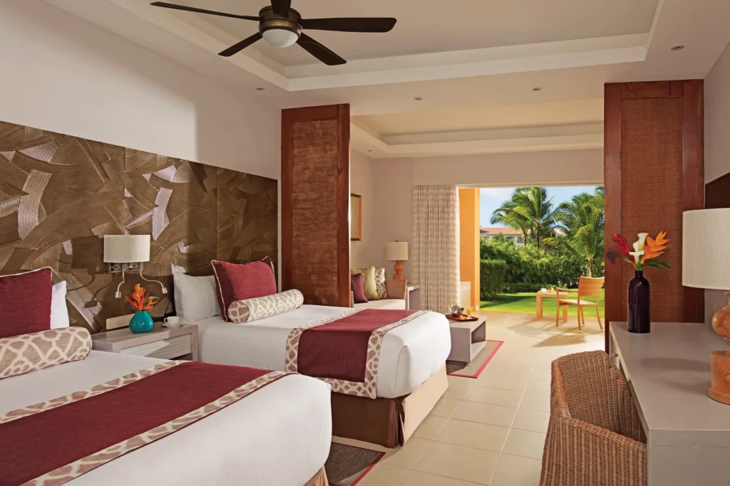 Deluxe Room with two double beds and private terrace at Dreams Royal Beach Punta Cana overlooking tropical gardens.
