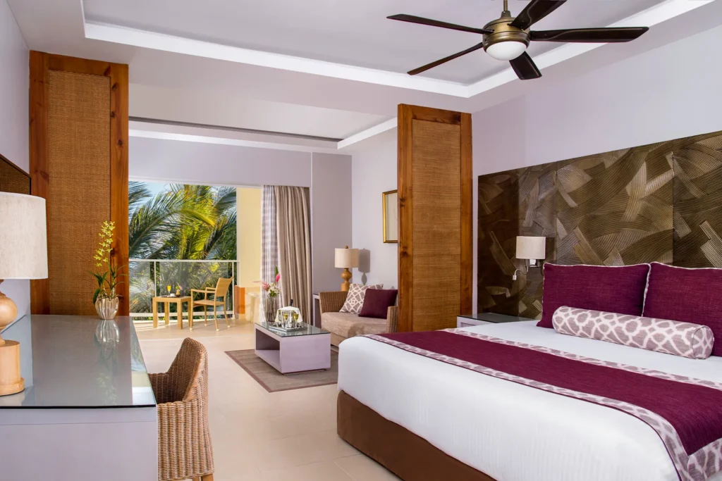 Deluxe Room with king bed, sitting area, and balcony at Dreams Royal Beach Punta Cana with resort view.