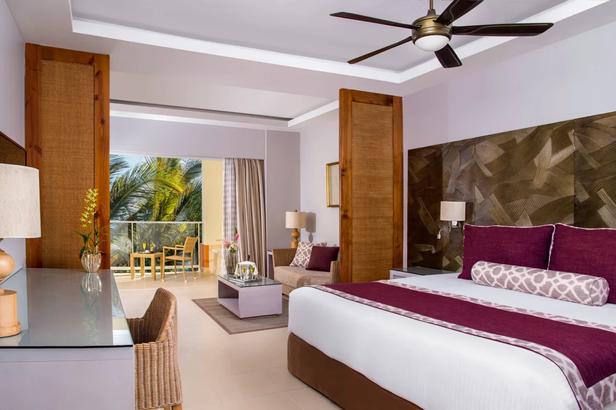 Deluxe Room with king bed, sitting area, and balcony at Dreams Royal Beach Punta Cana with resort view.