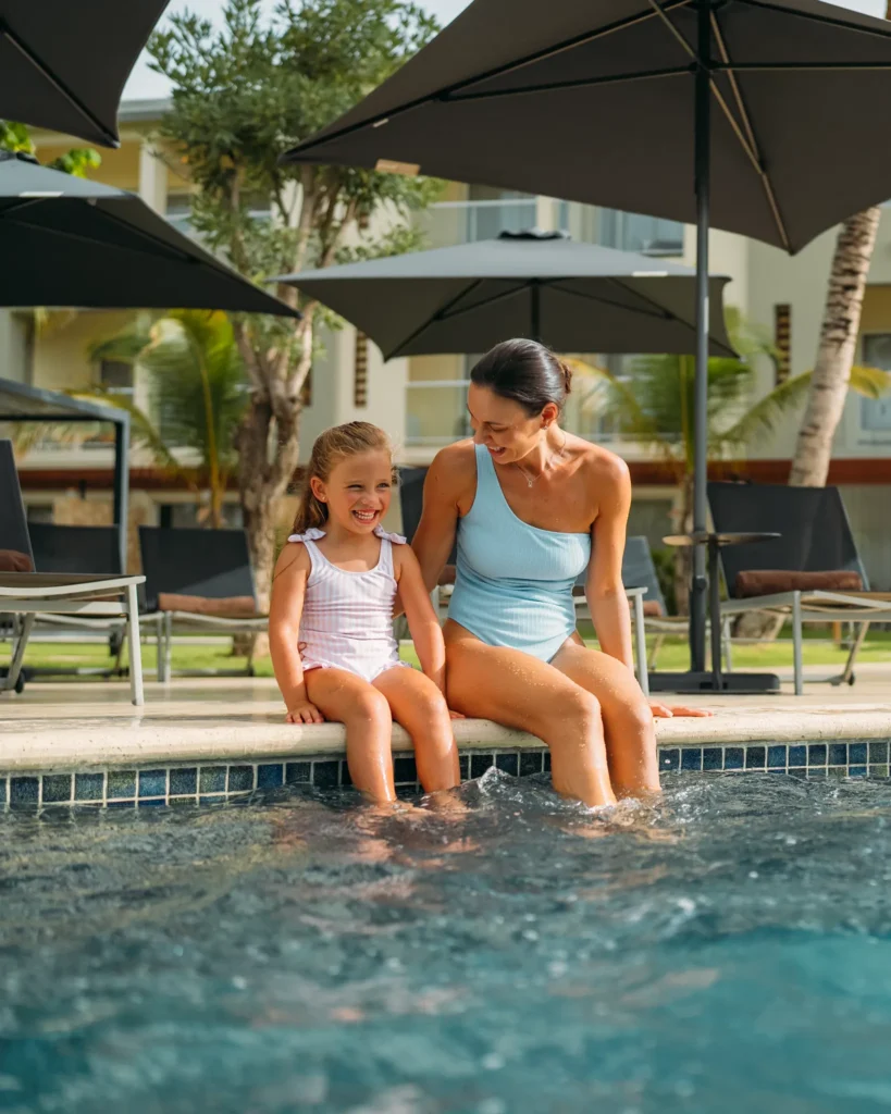 Mother and daughter relaxing at a poolside area at Dreams Royal Beach Punta Cana, enjoying a family-friendly resort experience.