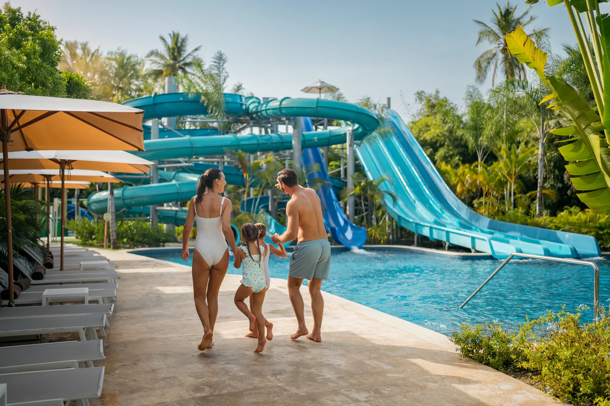 Family walking toward water slides at Dreams Royal Beach Punta Cana water park, perfect for kids and all ages.