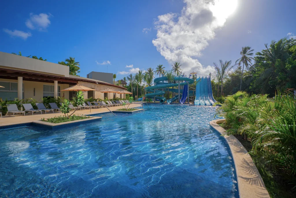 Large resort pool with water slides and sun loungers at Dreams Royal Beach Punta Cana.