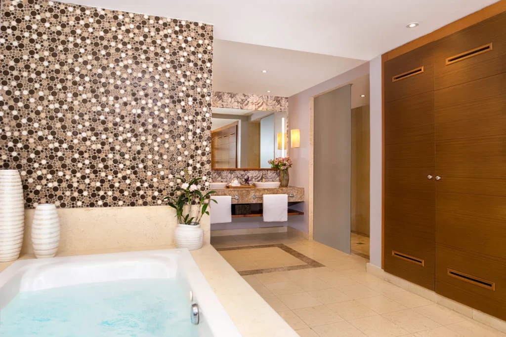 Luxury bathroom with soaking tub, dual vanity, and mosaic accent wall.