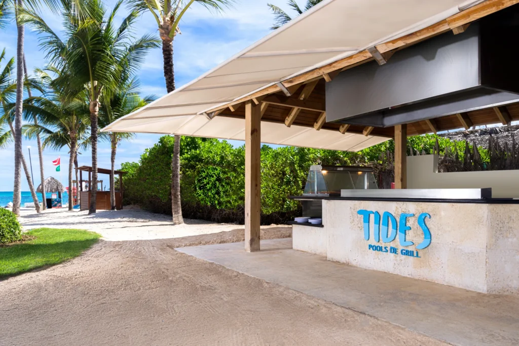 Tides Pool Side Grill at Dreams Royal Beach Punta Cana serving burgers and hot dogs in a casual beachfront poolside setting.