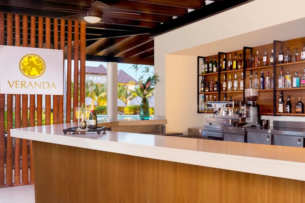 Veranda restaurant bar at Dreams Royal Beach Punta Cana featuring a relaxed open-air setting, stylish seating, and pre-dinner cocktails.