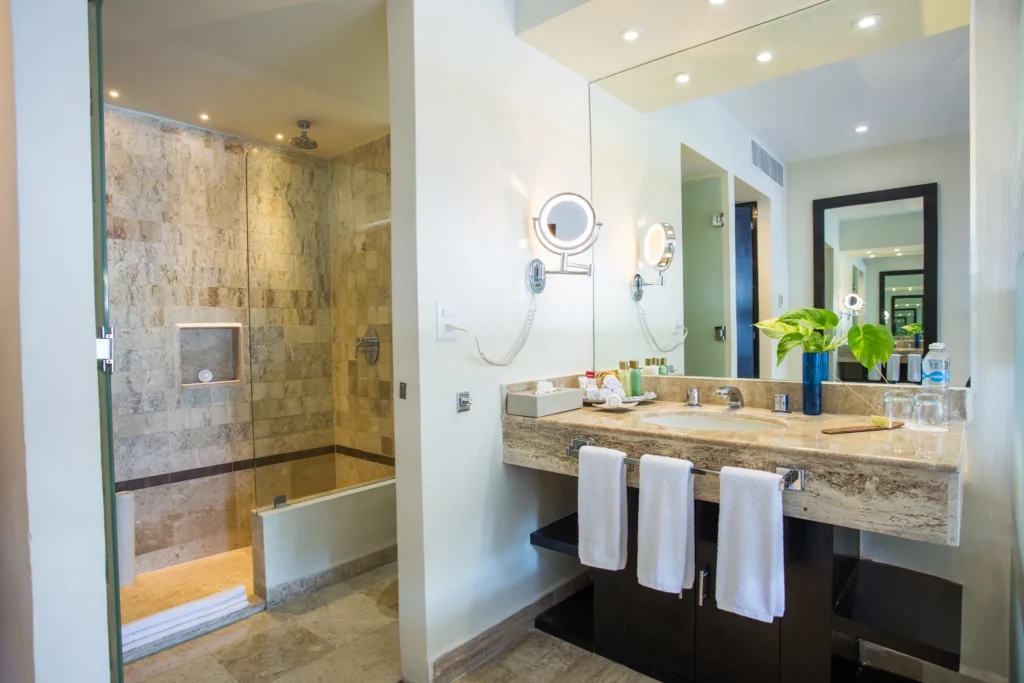Deluxe Partial Ocean View bathroom with walk-in shower and marble vanity at Dreams Sands Cancun Resort & Spa.