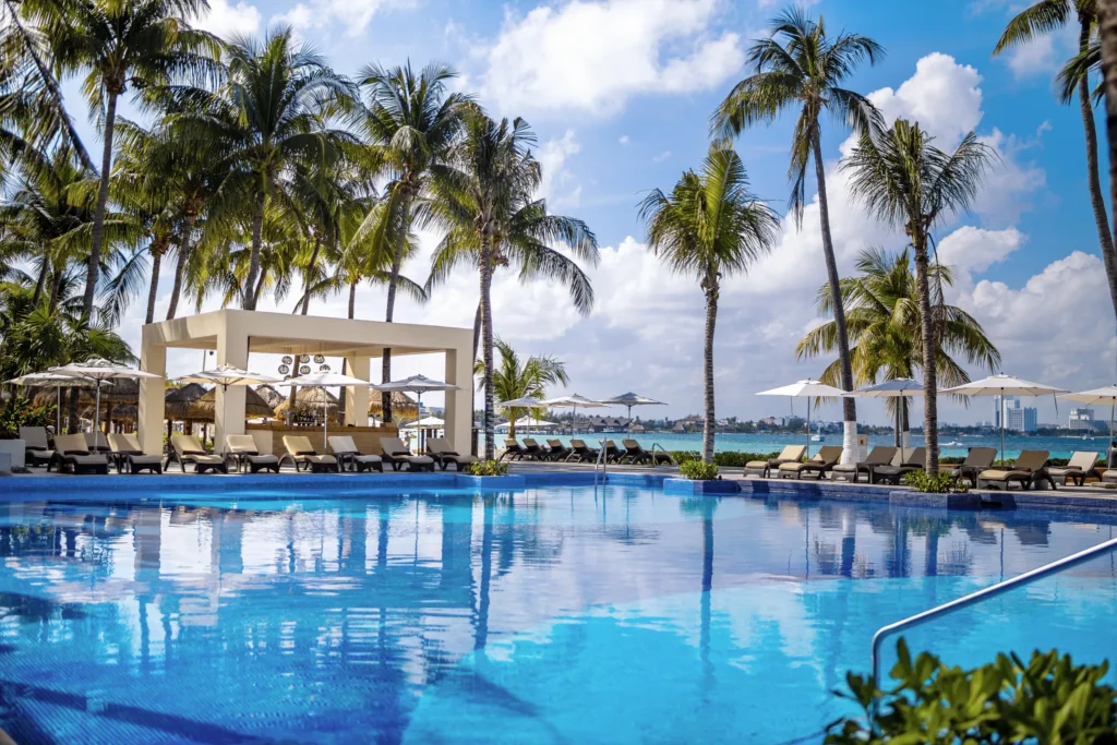 Main resort pool with palm trees and ocean views at Dreams Sands Cancun Resort & Spa.