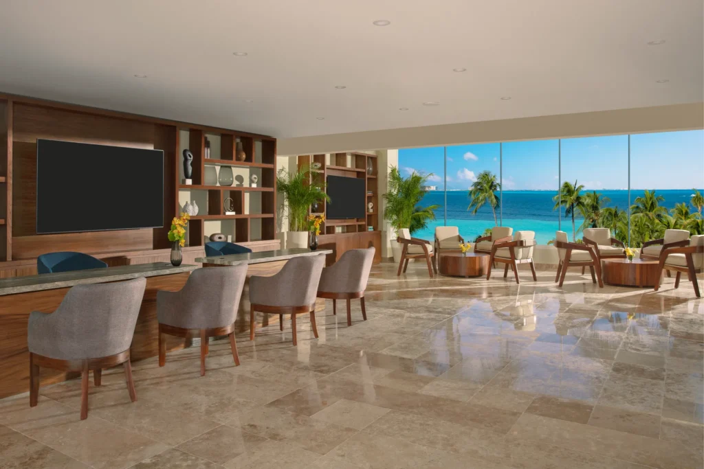 Preferred Club lounge with luxury seating and panoramic ocean views at Dreams Sands Cancun Resort & Spa.