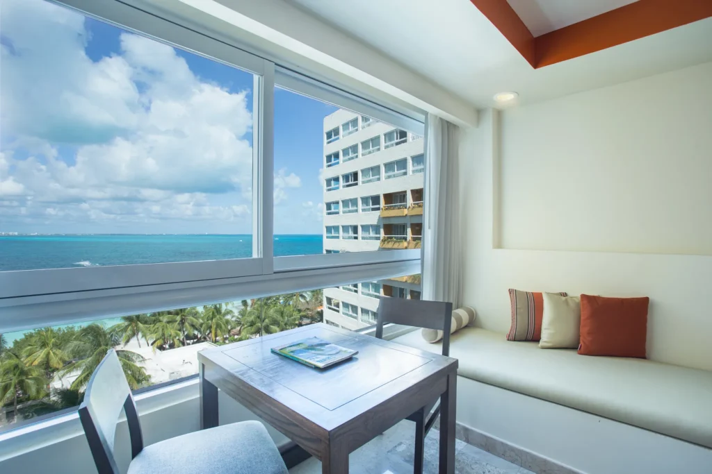 Preferred Club Junior Suite sitting area with panoramic oceanfront views at Dreams Sands Cancun Resort & Spa.