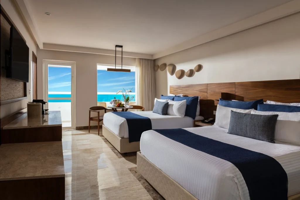 Preferred Club Premium Ocean Front with Balcony room featuring two double beds and ocean views at Dreams Sands Cancun Resort & Spa.