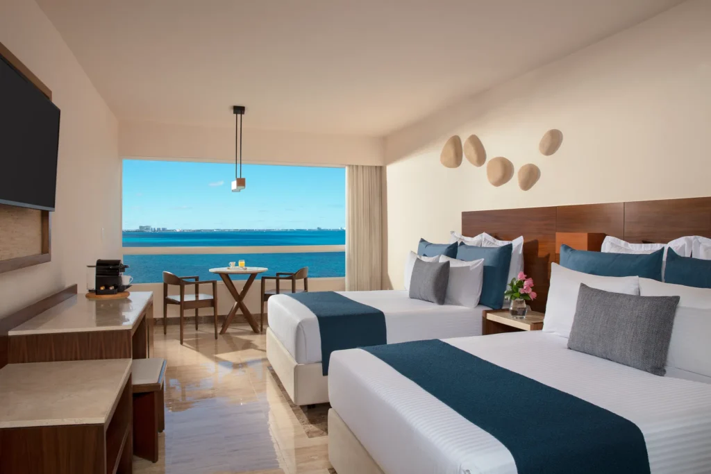 Preferred Club Premium Ocean Front room with two double beds and Caribbean Sea views at Dreams Sands Cancun Resort & Spa.