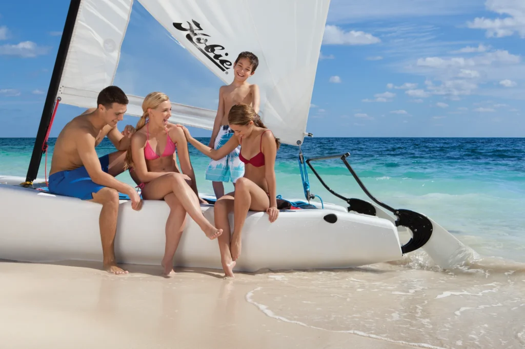 Family enjoying a catamaran sailing adventure on the Caribbean coast near Dreams Sapphire Resort & Spa.