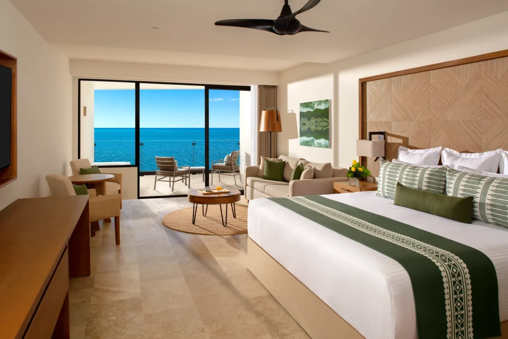 Club Junior Suite Ocean Front with king bed, sofa area, and private oceanfront balcony at Dreams Sapphire Resort & Spa.