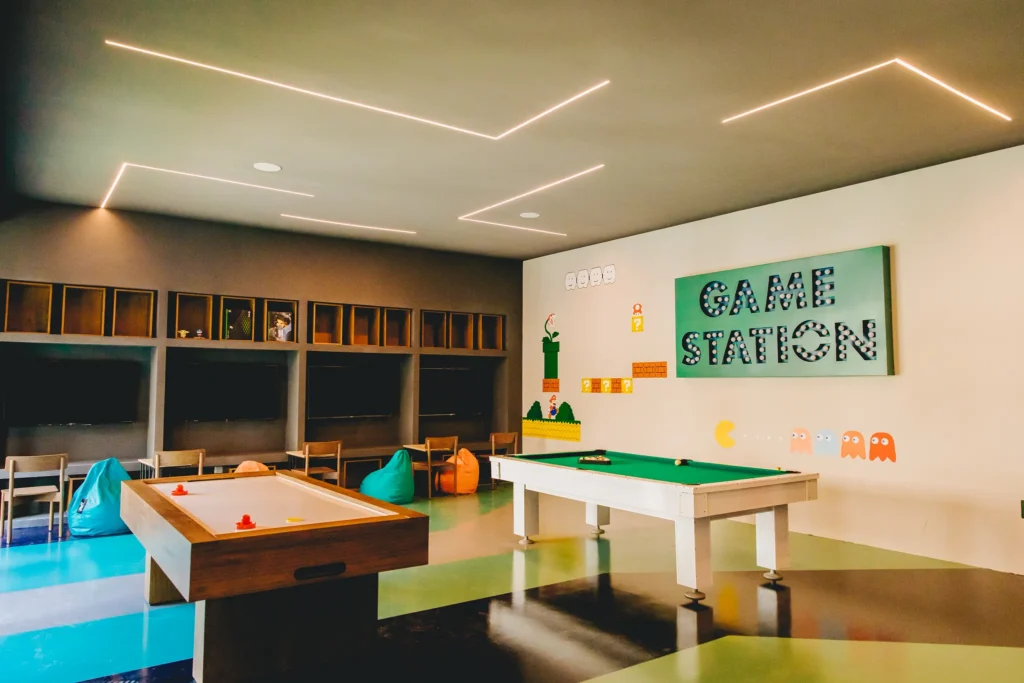Game room featuring arcade games, air hockey, and gaming stations at Dreams Sapphire Resort & Spa, providing fun entertainment for kids and teens.
