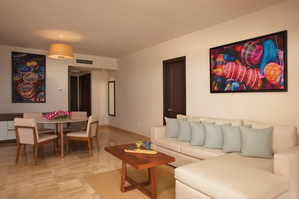 Preferred Club Master Suite Beach Front Swim Out living area with sofa bed and dining space at Dreams Sapphire Resort & Spa.