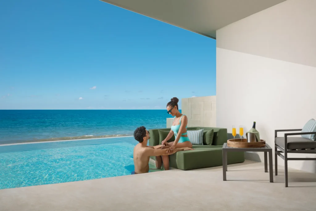 Couple relaxing by a private oceanfront plunge pool terrace at Dreams Sapphire Resort & Spa in Riviera Cancun.